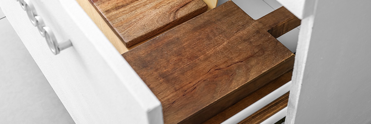 Drewniane deski do krojenia leżące w kuchennej szufladzie - tytułowa.