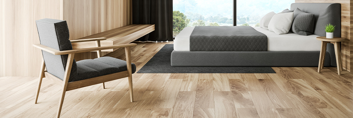 Nowoczesna i minimalistyczna sypiania z dużym łóżkiem i fotelem w kolorach jasnego drewna i szarości